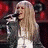 A pixelated image of a woman with long blonde hair singing into a microphone, next to stylized text reading 'Hannah Montana' in gold and purple.