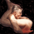 Pixelated static image of a nude female figure in a reclining pose against dark background with visible dithering and color banding.