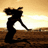 Silhouette of a figure in dynamic pose against gradient sky and ground, rendered with pixelated blocky style.