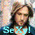 Pixelated static icon featuring a person with dark hair and beard wearing blue clothing, with large cyan text reading "SEX!" at the bottom against a gray background.