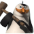 Pixelated snowman with orange carrot nose, blue eyes, black top hat, and black scarf holding brown wooden hammer against gray background.
