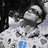 Pixelated grayscale image of a person in a patterned shirt with blue text overlays on a black background.