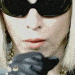 repeated facial images with changing expressions and star symbols on the face, wearing dark sunglasses and a blue jacket