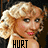 Pixelated close-up of a person with light brown curly hair, pink lips, and visible blush on cheeks against dark background.