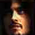 Pixelated static image of a stylized human face in profile with warm lighting and dark background.