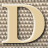 Static 48x48 pixel icon featuring a large stylized letter D with beige fill and brown checkered pattern, set against a gray background grid.