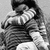Black-and-white animation of a person in striped clothing holding another figure, with subtle pose shifts across frames.