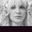 A grayscale image of a person with blonde hair and bangs, repeated in horizontal above a scrolling text banner