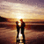 A pixelated sunset scene with two silhouetted figures embracing on a beach, transitioning to display red text and a heart symbol.