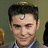 A pixelated image of a person with dark hair and a light blue shirt, with pink text overlay on the right side.