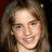 A four- shows a person with long brown hair in different poses and backgrounds, including close-up smiles and outdoor settings