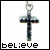 A silver cross pendant with dark inlaid details appears below the word 'believe' in pixelated text, which changes character by character across frames.