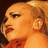 Pixelated image of a person with light brown hair in a high ponytail, wearing red clothing, against a black background with white pixelated text.
