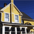 Pixelated image of a yellow house with white trim, dark roof, and two windows, set against a blue background.