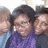 Group of people in a selfie-style photo with one person in purple clothing at center, others partially visible on sides.