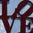 Dark brown stylized letters 'L' and 'P' on a light blue background with pixelated edges.