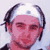 Pixelated static image of a person with light skin tone wearing headphones, set against a white background.