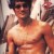 Pixelated image of a person with dark hair wearing a light-colored sleeveless top, standing against an indistinct background.
