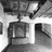 Black-and-white pixelated image showing a stylized building facade with a central vertical element and two rectangular sections, possibly a theater entrance.