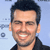 Static pixelated icon of a smiling man with short dark hair and stubble, wearing a black shirt against a light blue background.