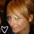 Two side-by-side pixelated images of a person with light brown hair, each featuring a heart-shaped icon below the face.