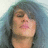 Pixelated close-up of a person with dark hair and closed eyes, lips slightly parted against a blue-toned background.