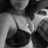 Black-and-white pixelated image of a person wearing a dark spaghetti-strap top with light-colored background and blurred shapes.