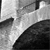 Grayscale abstract composition with diagonal light and dark regions, featuring a central bright streak and angular dark shapes against a pixelated background.