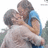 Two people embrace in a hug, one wearing a blue shirt, the other in a light-colored top, with red text reading "<3 Love is one Of a <3 Kind <3" on the right.
