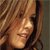 A pixelated close-up of a person with light brown hair, showing a smiling mouth and visible teeth against a neutral background.