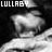 Pixelated grayscale image with 'LULLABY' text at top, featuring a central abstract shape on dark background.
