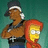 Pixelated image of two cartoon characters: a man with brown skin wearing a black cap and dark shirt, and a yellow-haired character with a red hooded garment.