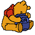 Pixelated cartoon bear in orange with red shirt and blue pants, holding a blue jar with visible text, seated against gray background.