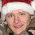 A person wearing a red and white Santa hat with visible facial features, clothing details, and background elements