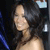 Pixelated image of a person with dark hair and light skin, wearing a dark top against a dark background with blue and white elements.