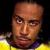 Pixelated static image of a person's face with yellow and purple clothing against dark background