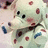 Pixelated cartoon character with red spots on light green body, blue accents, and black eyes; text reads "Merry" and "Christmas!" in red pixel font.