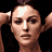 Pixelated close-up of a person with light skin tone, dark hair, and a white mark on the forehead, arms raised against a black background.