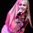 Pixelated image of a person with long pink hair holding a microphone, split into four quadrants with text on two purple sections and one gray section.