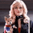 A pixelated image showing a woman with blonde hair holding two dogs, next to green text reading "Original Icons .com" on a dark background.