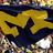 A four-quadrant image with yellow, dark blue, and gray sections displaying text and a pixelated crowd scene.