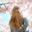 A four- shows a woman with long brown hair in different poses: under pink cherry blossoms, on a beach, and with a dog, plus text at the bottom