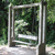 Pixelated static image of a metal-framed structure with vertical posts and horizontal rails, set against a blurred green foliage background.