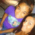 Pixelated image of two figures in close embrace, one wearing a purple top with light blue accents, the other in light brown tones, against a dark background.