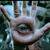 A pixelated close-up of a hand with fingers extended, palm facing forward, against a blurred background of blue and green tones.