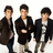Six young men in dark jackets and light pants stand in a against a white background with orange text overlays