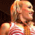 A woman with blonde hair in a high ponytail appears in three showing her holding a microphone, smiling, and laughing while wearing a red-and-white striped sleeveless top