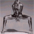 A static pixelated image shows a dark figure standing on a light rectangular base against a gradient background.