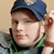 Static 50x50 pixel icon showing a person wearing a blue cap and green straps with brown hair, visible against a light background.