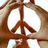 Brown peace sign symbol with light brown border on white background, displayed in a